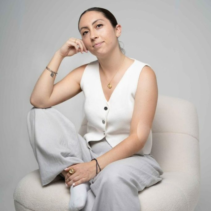 Judith Granados, psicóloga en Sabadell, sentada y pensativa en un sillón blanco